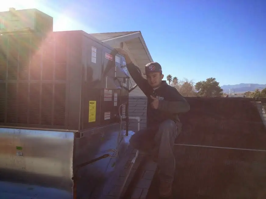 HVAC technician performing AC Tune-Up on a rooftop unit in Coal